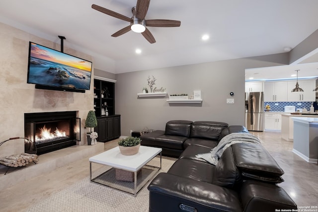 living room featuring ceiling fan and a fireplace