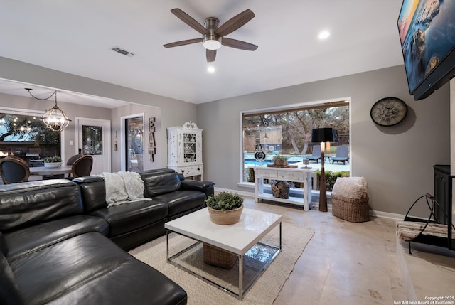 living room featuring ceiling fan with notable chandelier