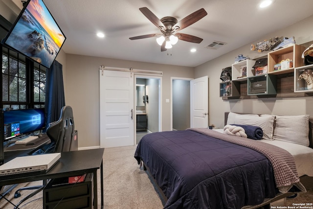 carpeted bedroom featuring ceiling fan and a barn door