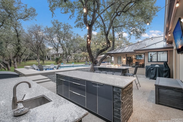 view of patio / terrace with a grill, a fenced in pool, and an outdoor wet bar