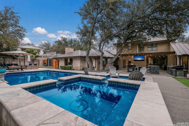 view of swimming pool featuring exterior bar, a patio area, and an in ground hot tub