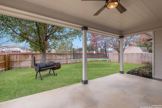 view of patio featuring a trampoline, grilling area, and ceiling fan