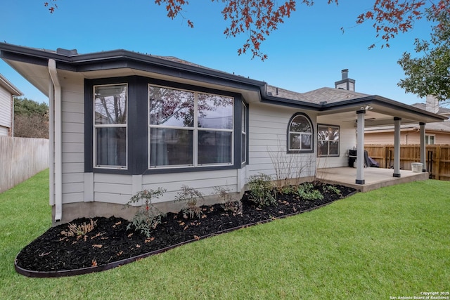 rear view of house featuring a patio and a lawn