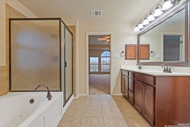 bathroom with vanity, tile patterned floors, plus walk in shower, and a textured ceiling