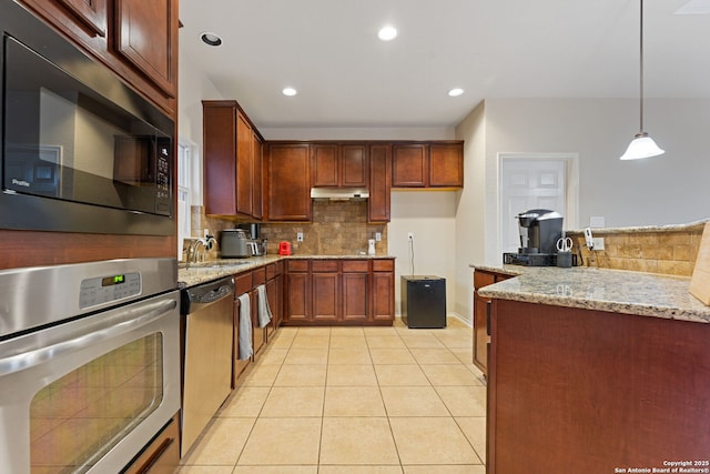 kitchen with stainless steel appliances, tasteful backsplash, hanging light fixtures, and light stone counters