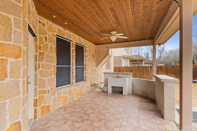 view of patio with ceiling fan and sink