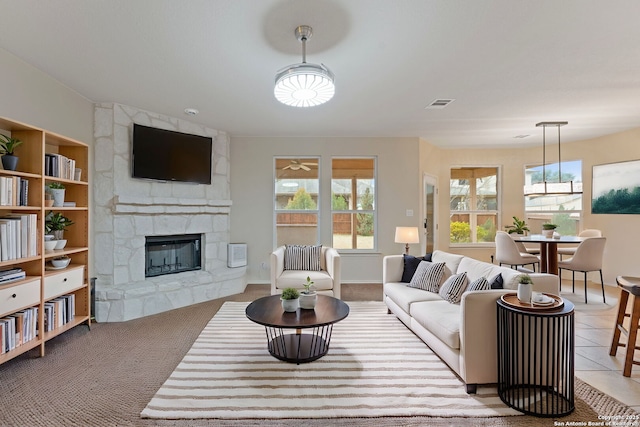 living room featuring plenty of natural light, light tile patterned floors, and a fireplace