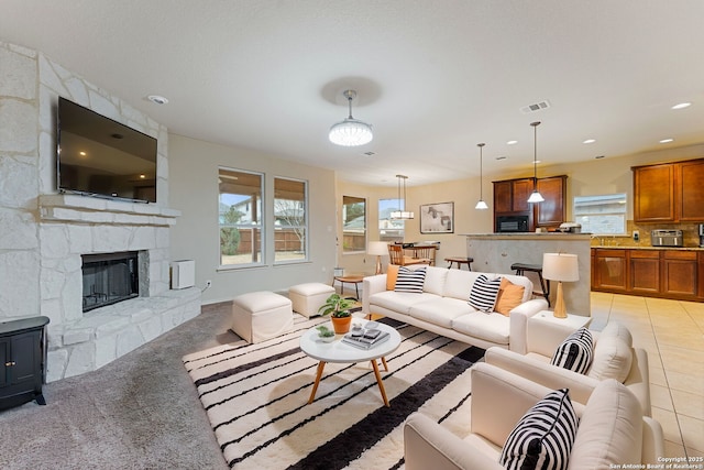 tiled living room with a stone fireplace