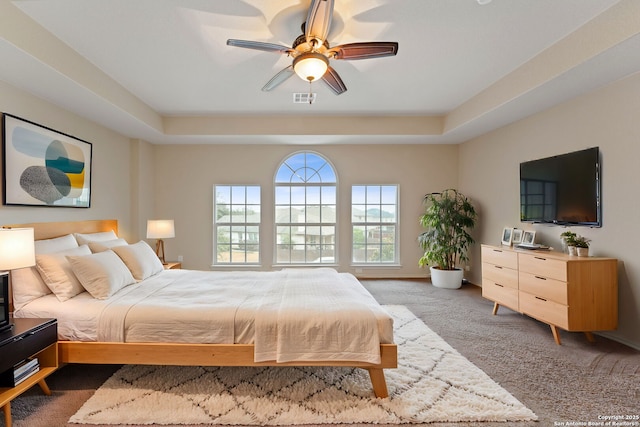 bedroom featuring a tray ceiling, ceiling fan, and carpet flooring