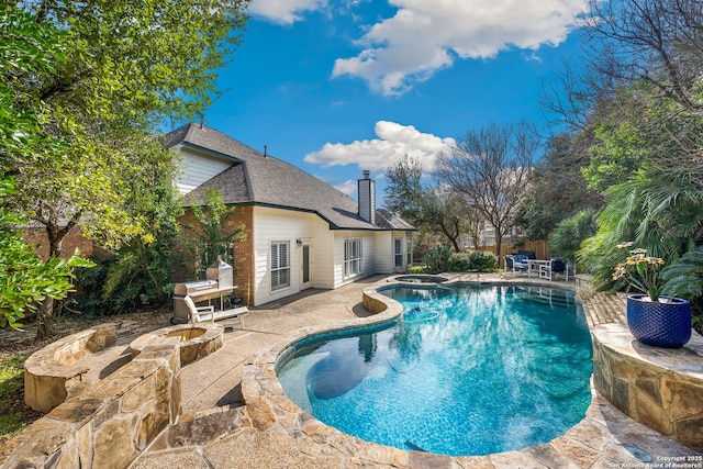 view of swimming pool with a patio area, a fenced in pool, and an in ground hot tub