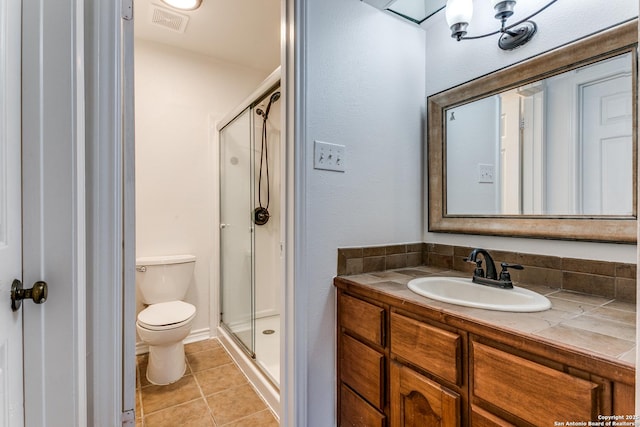 bathroom featuring vanity, tile patterned floors, toilet, and walk in shower