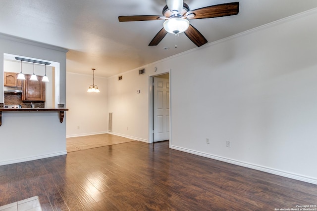 unfurnished living room featuring crown molding, ceiling fan, and dark hardwood / wood-style floors