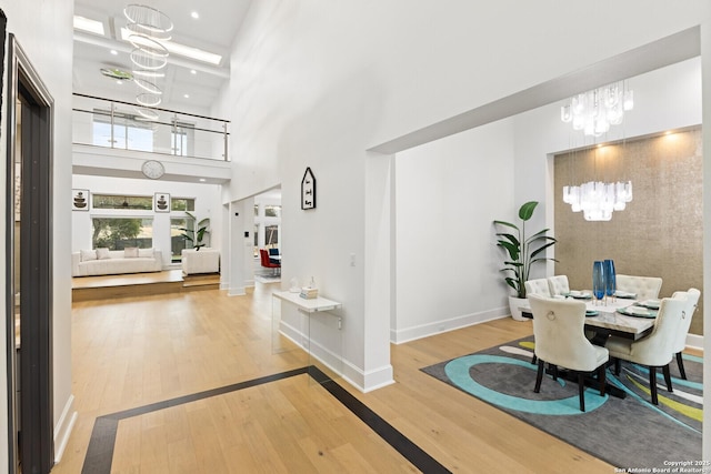 entrance foyer with a chandelier, hardwood / wood-style floors, and a high ceiling