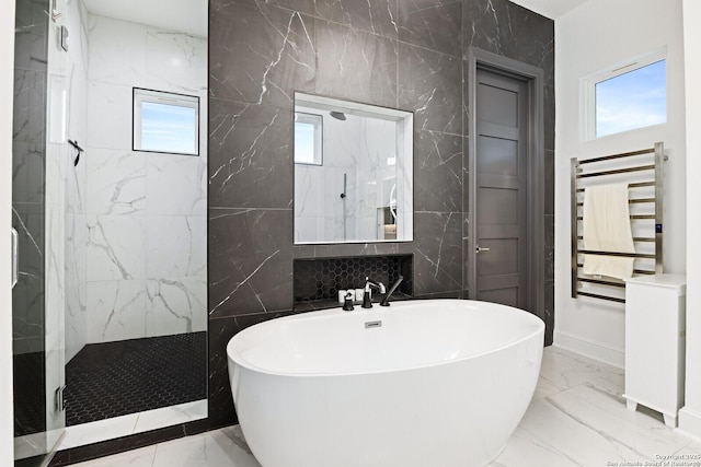 bathroom featuring shower with separate bathtub, radiator, and tile walls