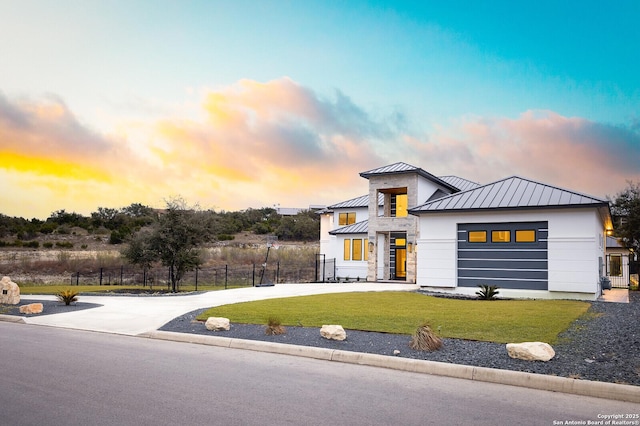 view of front of home with a garage and a lawn