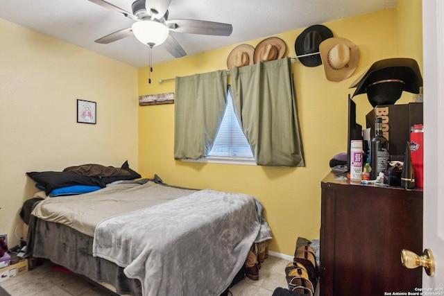 tiled bedroom with a ceiling fan and baseboards