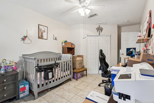 bedroom featuring visible vents, a ceiling fan, a textured ceiling, a closet, and light tile patterned floors