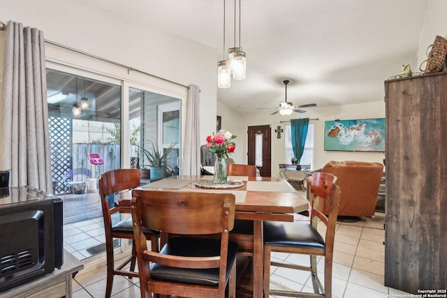 dining room with light tile patterned flooring, a ceiling fan, and vaulted ceiling