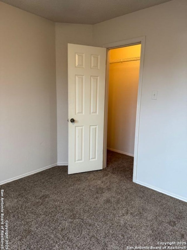 unfurnished bedroom featuring dark carpet