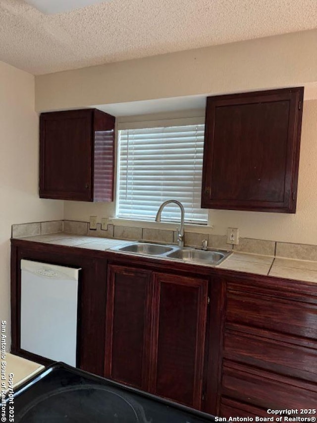 kitchen with dishwasher, sink, and a textured ceiling