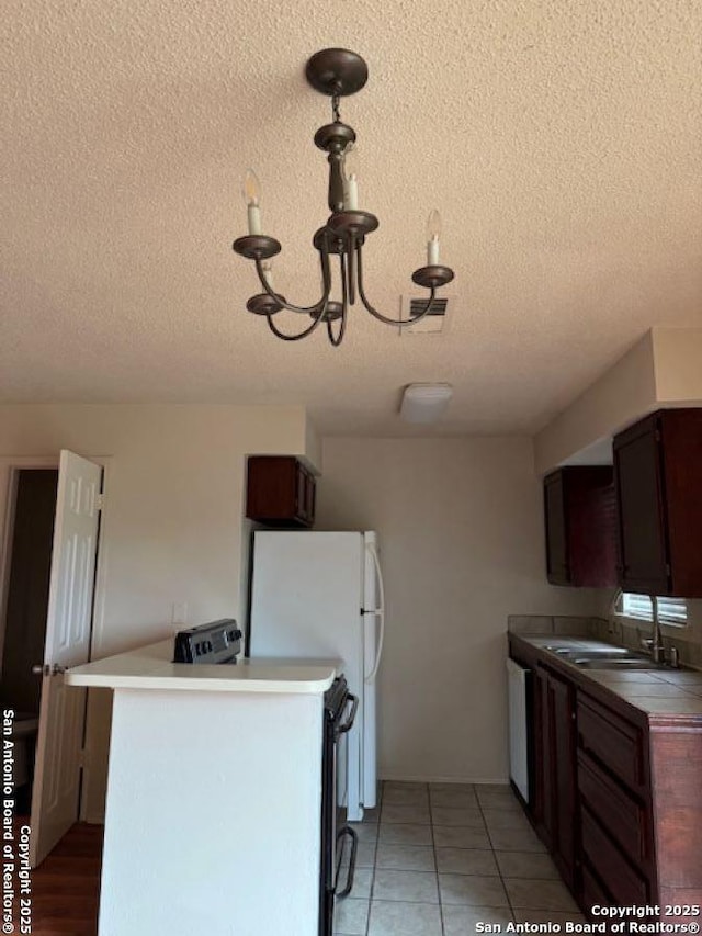 kitchen with sink, a textured ceiling, white appliances, and kitchen peninsula