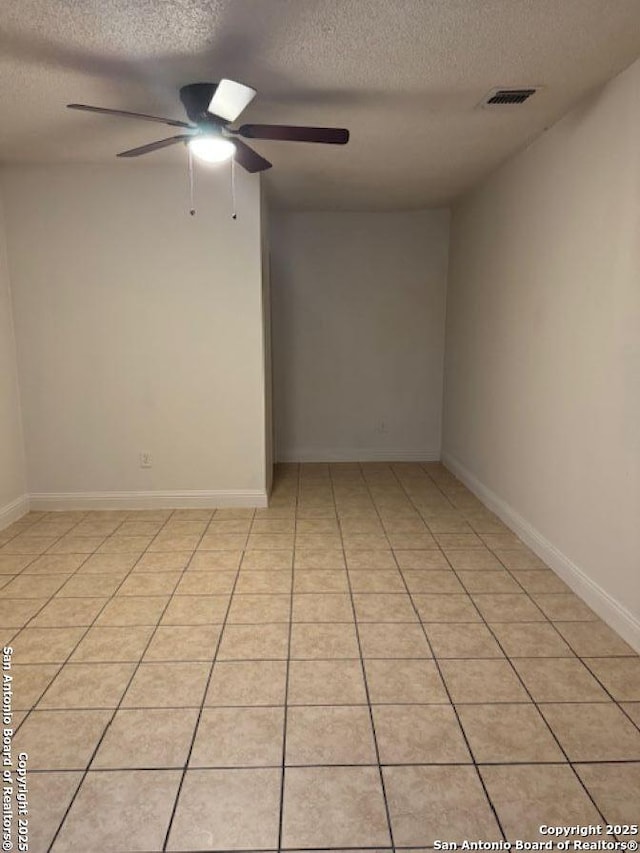 tiled spare room featuring a textured ceiling and ceiling fan