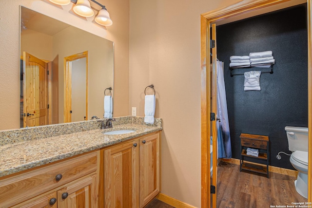 bathroom featuring vanity, hardwood / wood-style floors, and toilet