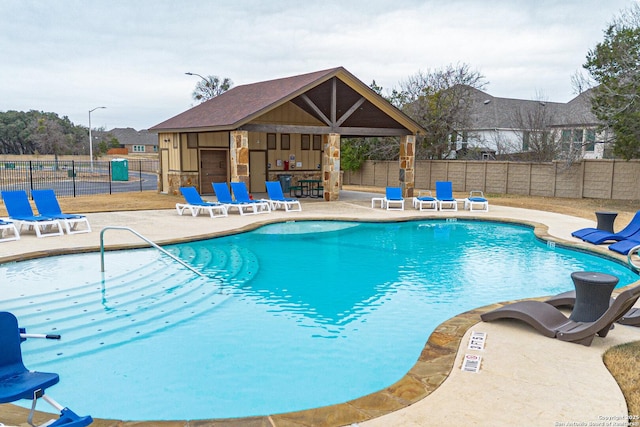 view of swimming pool featuring an outbuilding and a patio area