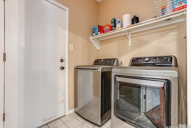 clothes washing area featuring light tile patterned flooring and washing machine and clothes dryer