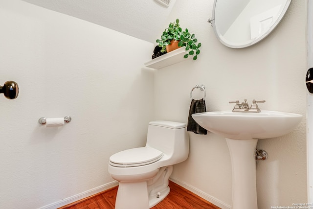 bathroom with hardwood / wood-style flooring and toilet