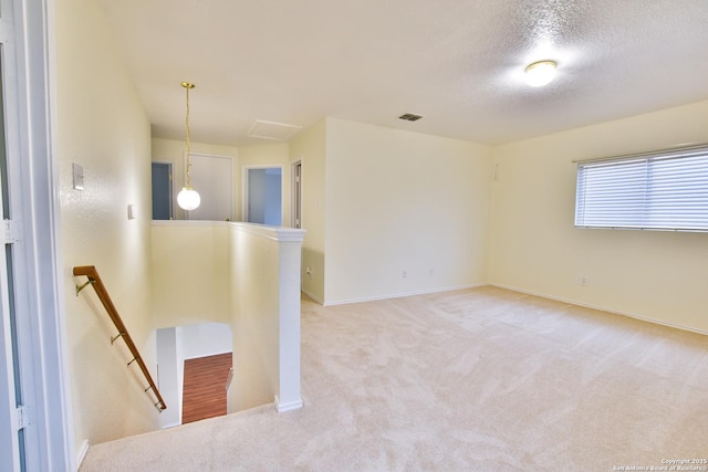 carpeted empty room featuring a textured ceiling