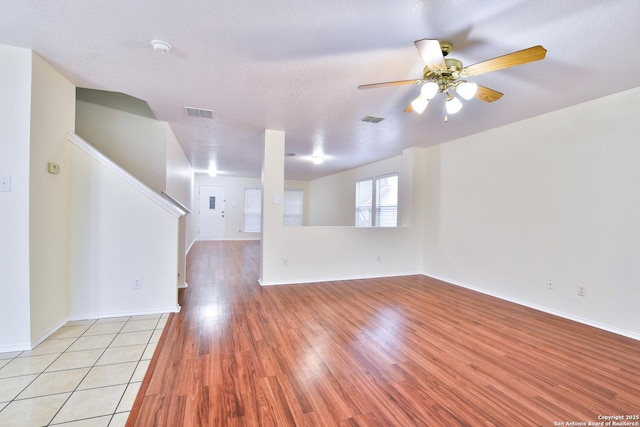 empty room featuring ceiling fan, light hardwood / wood-style floors, and a textured ceiling