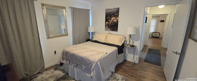 bedroom with dark wood-type flooring