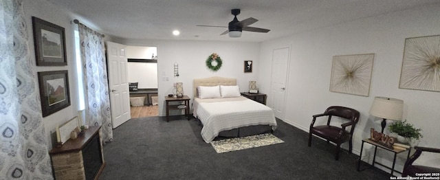 bedroom featuring connected bathroom, dark carpet, and ceiling fan