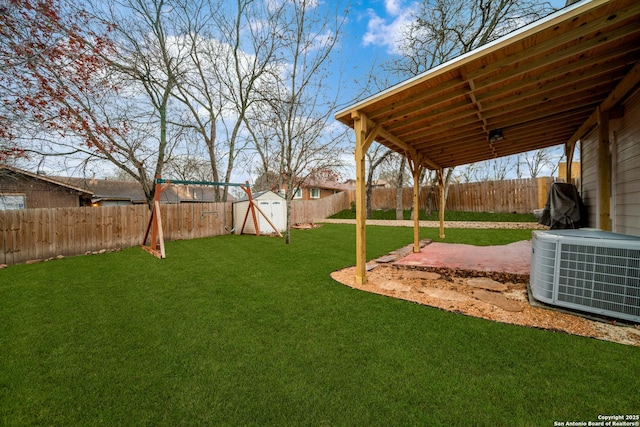 view of yard with central AC, a storage unit, and a patio