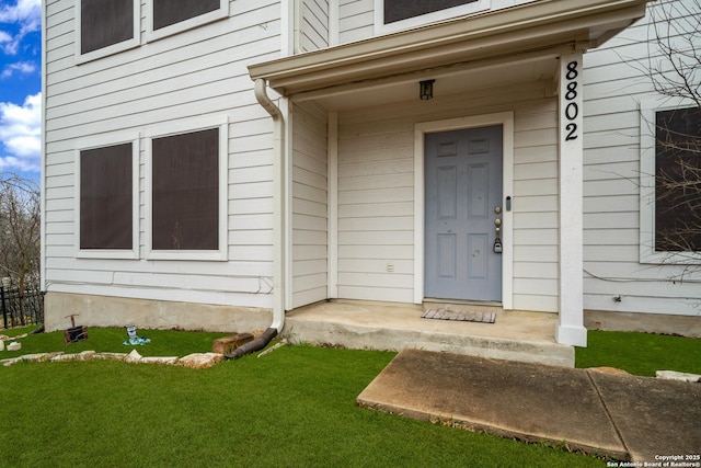 entrance to property with a lawn