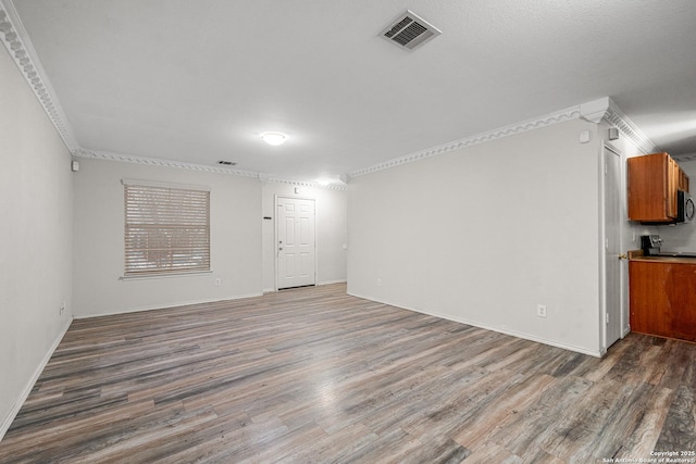 unfurnished living room featuring crown molding and dark wood-type flooring