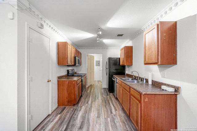 kitchen with sink, wood-type flooring, and appliances with stainless steel finishes