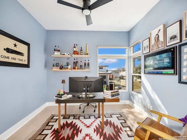 home office with ceiling fan and light hardwood / wood-style floors