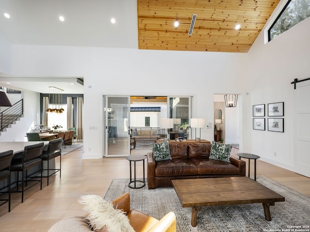 living room featuring plenty of natural light, high vaulted ceiling, and light hardwood / wood-style flooring