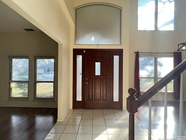 entryway featuring a high ceiling and light tile patterned floors