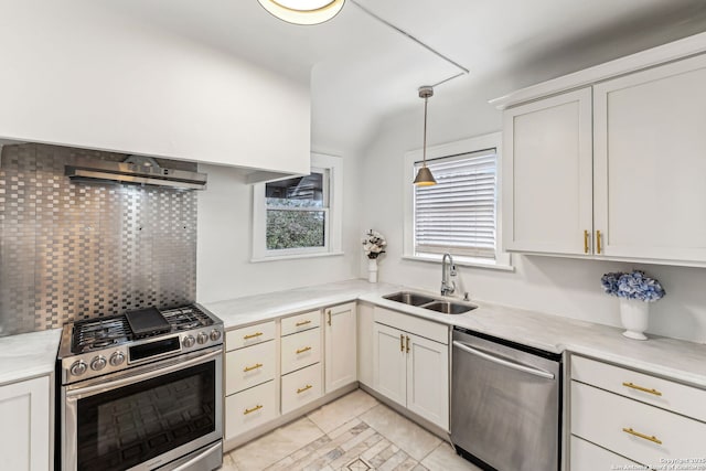 kitchen with hanging light fixtures, white cabinetry, appliances with stainless steel finishes, and sink