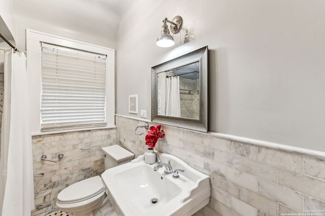 bathroom featuring tile walls, sink, and toilet