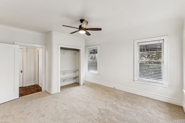 unfurnished bedroom featuring light carpet, multiple windows, a closet, and ceiling fan