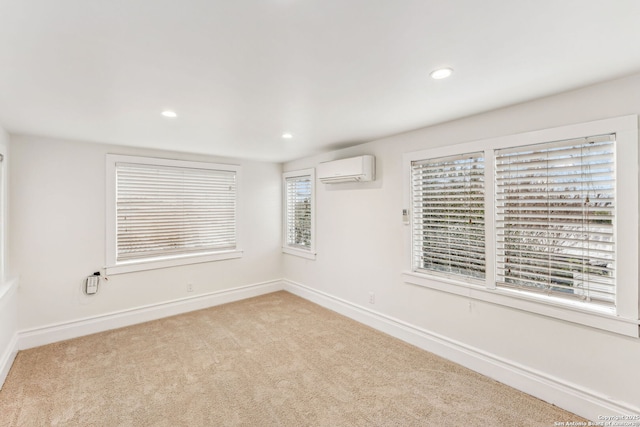 unfurnished room featuring light colored carpet and a wall mounted air conditioner