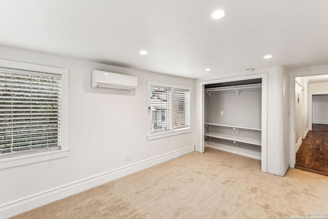 unfurnished bedroom featuring light colored carpet, a closet, and a wall mounted AC