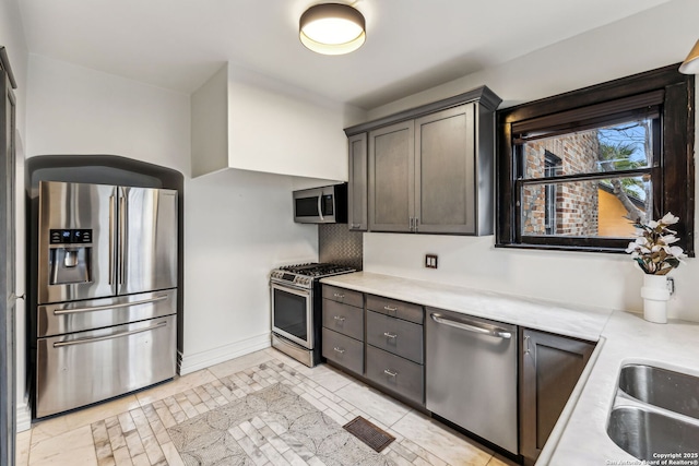 kitchen featuring dark brown cabinetry, stainless steel appliances, and decorative backsplash