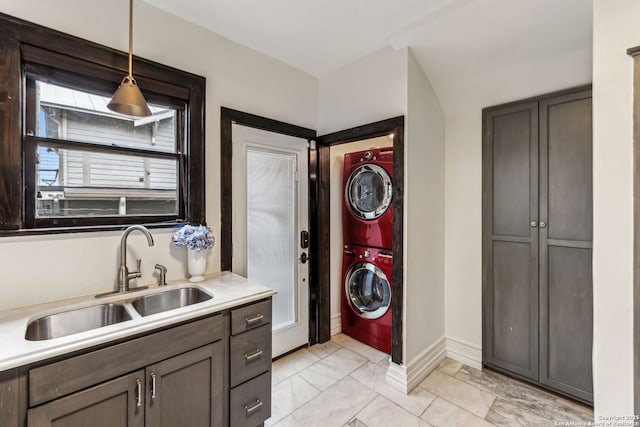 clothes washing area featuring stacked washer and dryer and sink