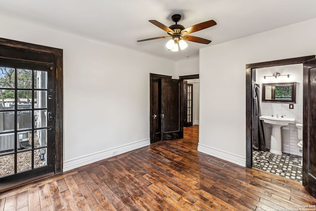 unfurnished bedroom featuring sink, dark wood-type flooring, and ensuite bathroom