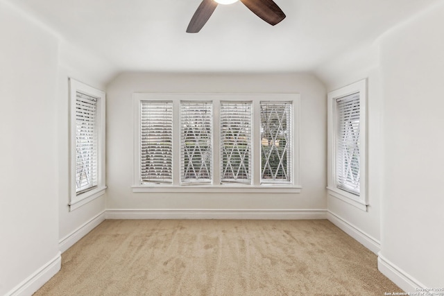 carpeted empty room with vaulted ceiling and ceiling fan